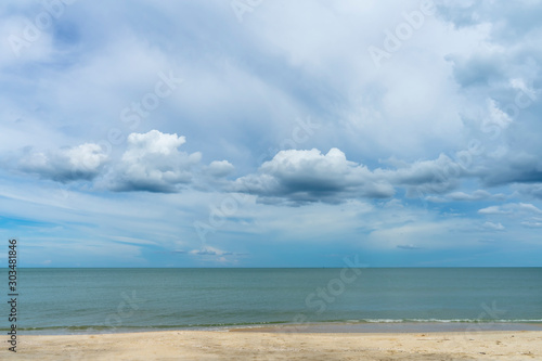 Nobody on the beach with blue sky and clouds in rain season.