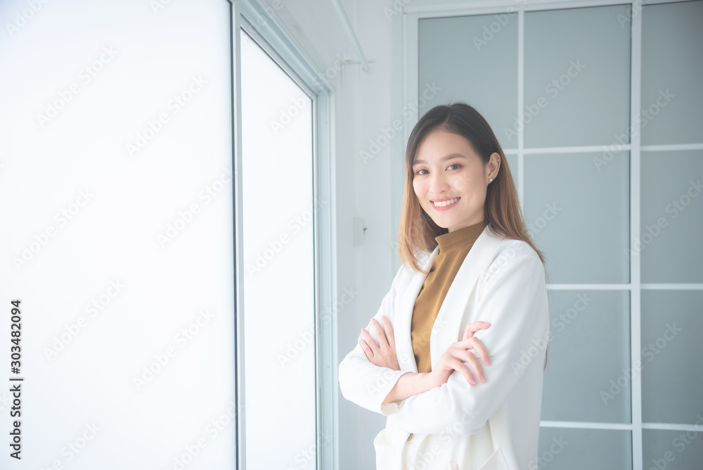Beautiful asian businesswoman standing in office and looking at camera with smiles. Beautiful asian businesswoman standing in office and looking at camera with smiles.