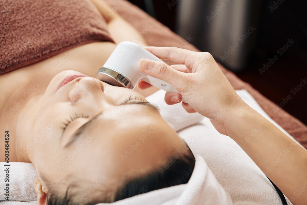 Obraz na plátně Process of cosmetologist doing ultrasound micromassage with special innovative t