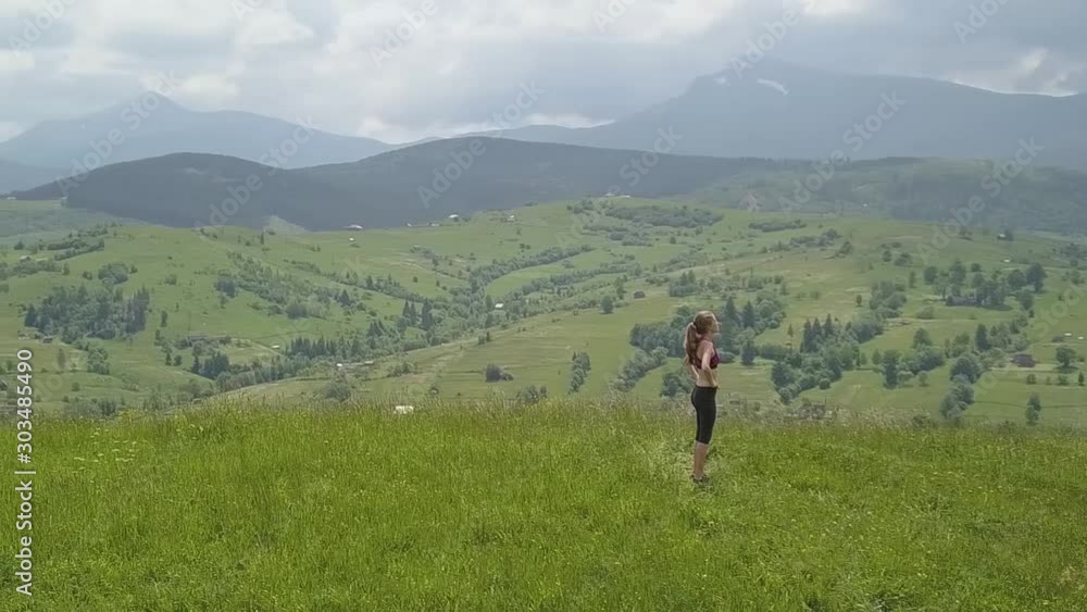 Young woman enjoying mountain view on a summer day. Relax and meditation in nature environment. Young woman enjoying mountain view on a summer day. Relax and meditation in nature environment.