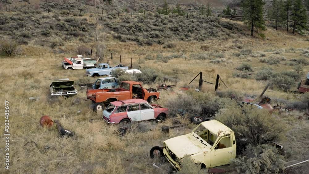 Aerial: Abandoned rusted out pickup trucks & cars. Rocky Mountains. British Columbia, Canada. Aerial: Abandoned rusted out pickup trucks & cars. Rocky Mountains. British Columbia, Canada.
