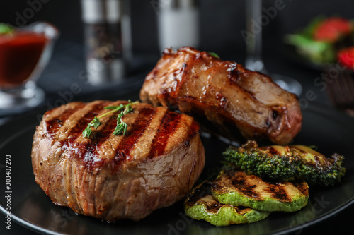 Closeup view of delicious grilled beef medallions served on table photo