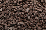 Delicious chocolate chips as background, top view