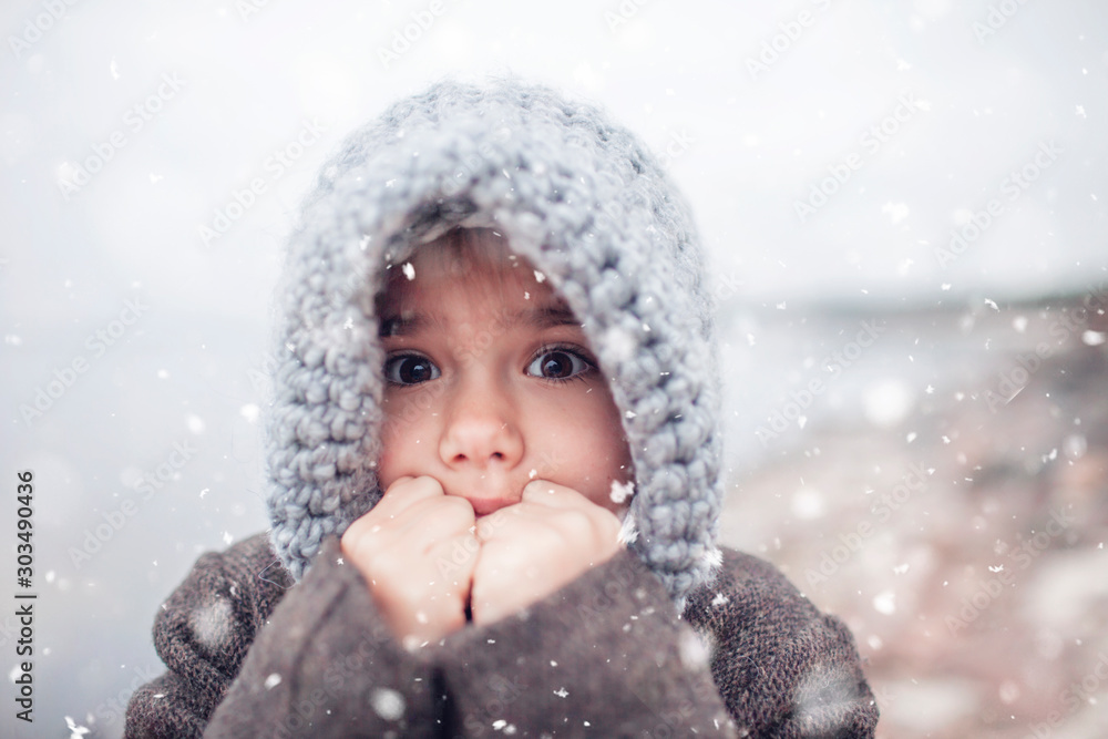 Girl in knitted grey hat hugging her frozen smaller brother Girl in knitted grey hat hugging her frozen smaller brother