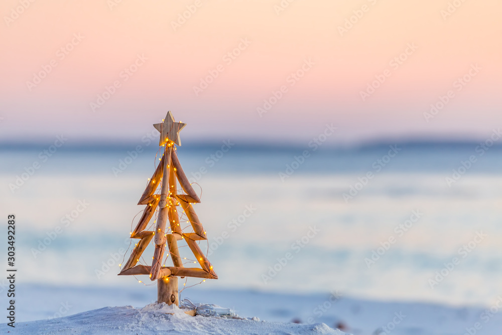 Christmas tree with fairy lights on the beach in summer - obrazy, fototapety, plakaty 