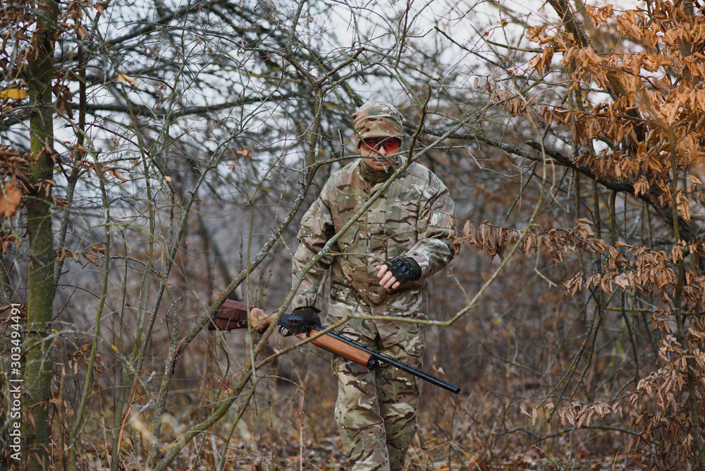 Naklejka premium Hunting permit. Man brutal gamekeeper nature background. hunter spend leisure hunting. Hunter hold riffles. Focus and concentration of experienced hunter. Hunting and trapping seasons.