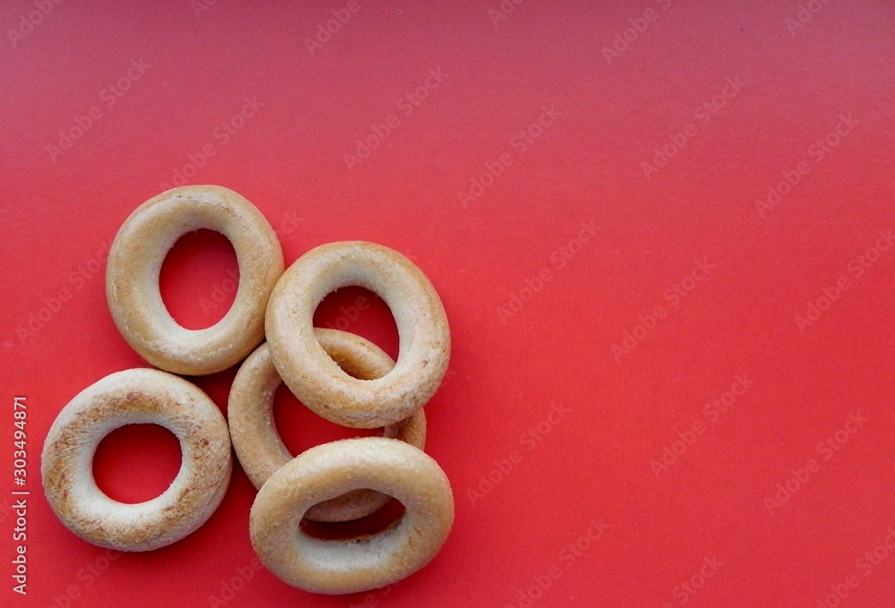 Fototapeta premium Bagels on a red background, located on the side, with space for text