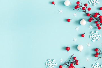 Christmas or winter composition. Snowflakes and red berries on blue background. Christmas, winter, new year concept. Flat lay, top view, copy space