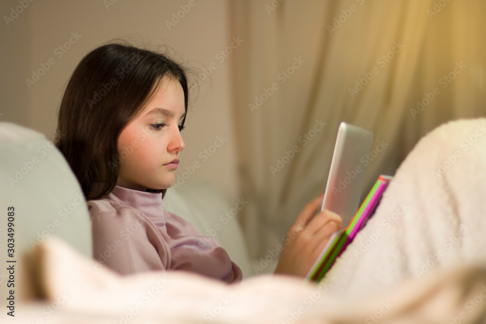 Teenager doing homework for school researching information on the tablet Teenager doing homework for school researching information on the tablet