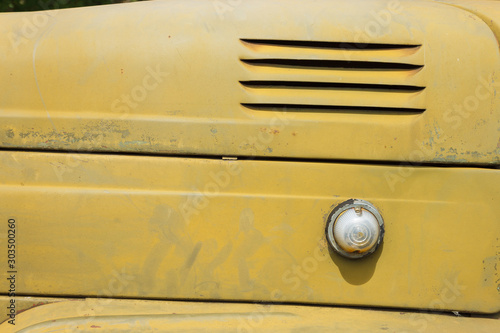 Details of the bonnet of a Soviet military truck. Side turn signal lights. Design elements and details of an old camouflage surface with exfoliated paint on a military truck. Car detail. Close-up