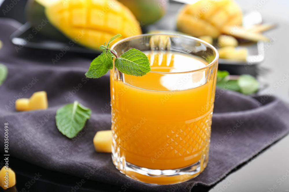 Fototapeta premium Glass of tasty mango juice on table