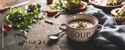 Photos Bowl with lentil soup on rustic kitchen table background with spoon and various ingredients