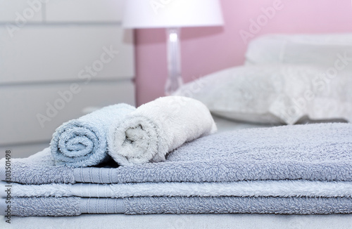 Stack of bath towels on bed decoration in bedroom interior