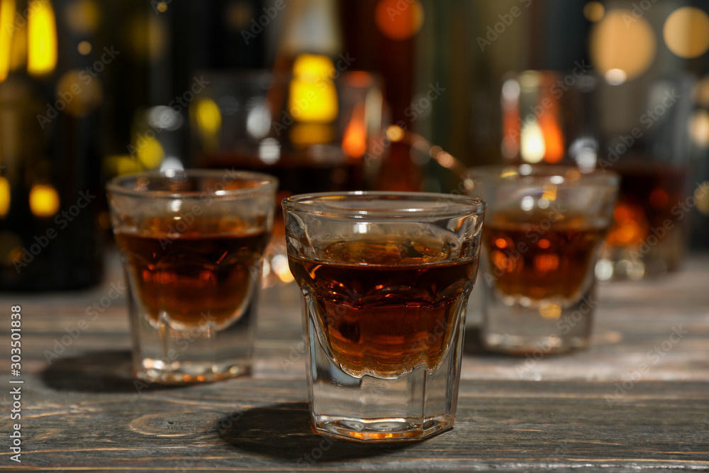 Whiskey shots on wooden bottled table, close up Whiskey shots on wooden bottled table, close up