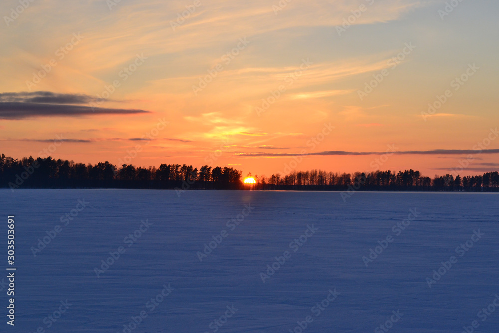 Winter sunset on lake Otradnoe in the Leningrad region of Russia.
