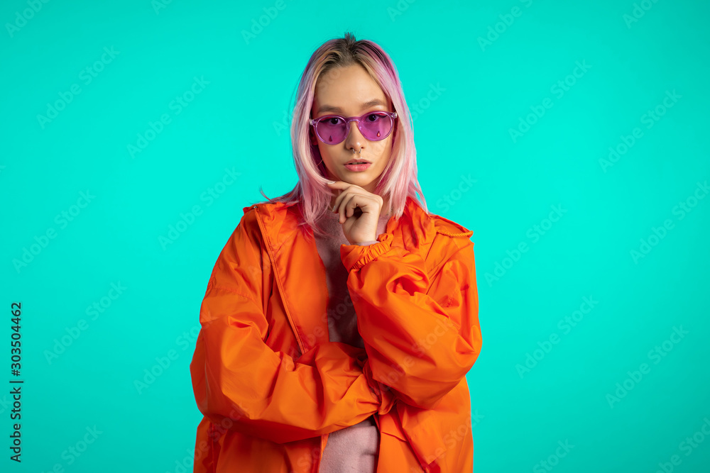 Millennial enigmatic pretty girl with unusual pink dyed hairstyle. Golden sequins as tears, nose piercing. Mysterious hipster teenager on blue background. Millennial enigmatic pretty girl with unusual pink dyed hairstyle. Golden sequins as tears, nose piercing. Mysterious hipster teenager on blue background.
