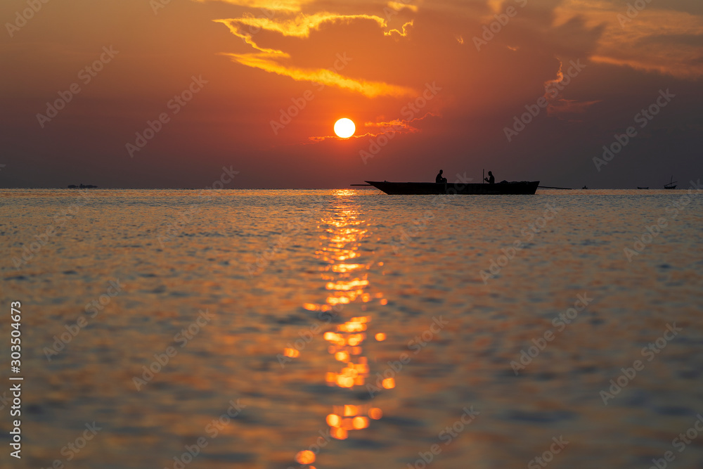 Traditional fisherman dhow boat during sunset on Indian ocean in island Zanzibar, Tanzania, East Africa