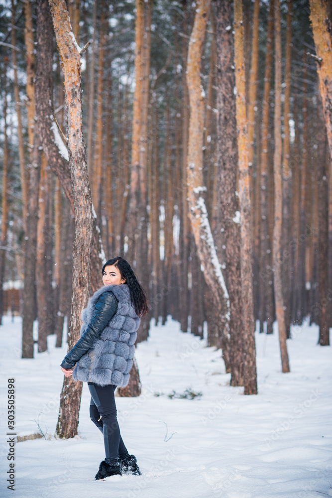 Winter holidays concept. Arabic woman in stylish look at snowy day outside