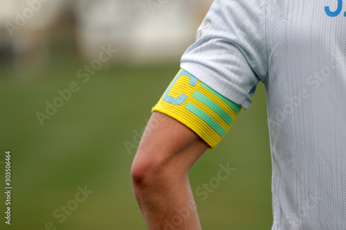 Captain of the football team on the stadium field. Sports background-the hand of the team captain with the identifying distinctive ribbon of the captain, official leader of team of footballers photo