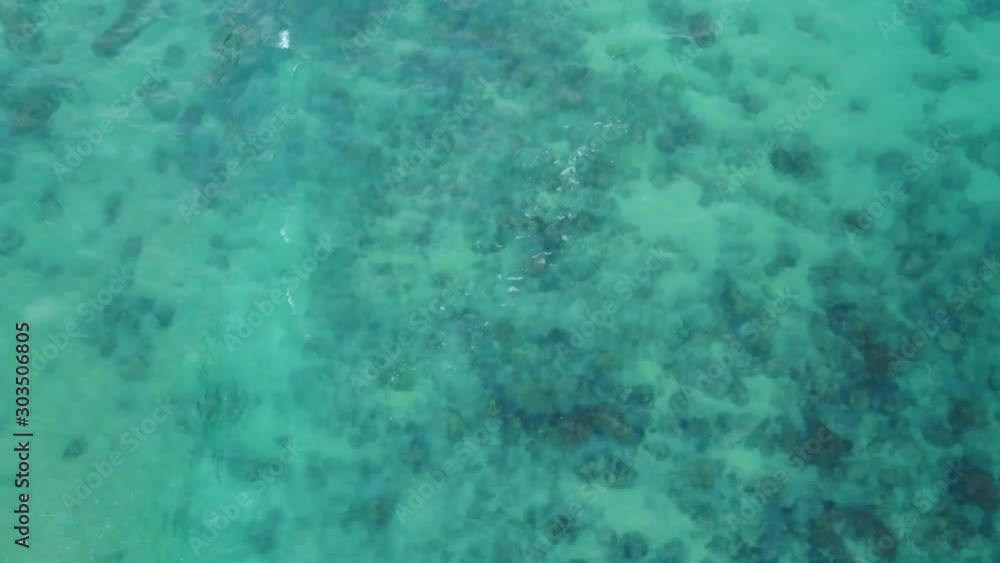 Aerial Drone Panning Above Crystal Clear Turquoise Blue Ocean Water On A Sunny Day With Rocky Sandy Bottom Aerial Drone Panning Above Crystal Clear Turquoise Blue Ocean Water On A Sunny Day With Rocky Sandy Bottom