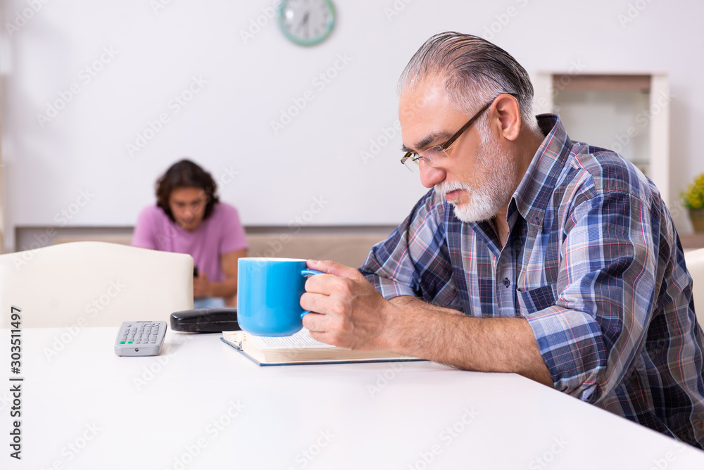 Young student and his old grandpa at home Young student and his old grandpa at home