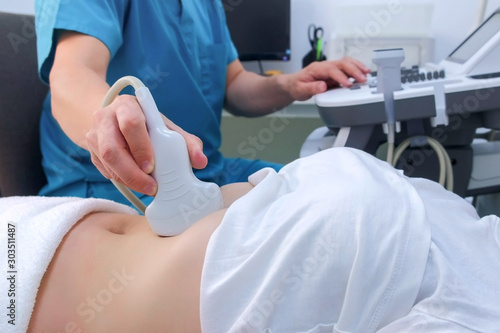 Wallpaper Mural Ultrasound diagnostic of stomach on abdominal to woman in clinic, closeup view. Doctor runs ultrasound sensor over patient's girl tummy and looks at image on screen. Diagnosis of internal organs. Torontodigital.ca