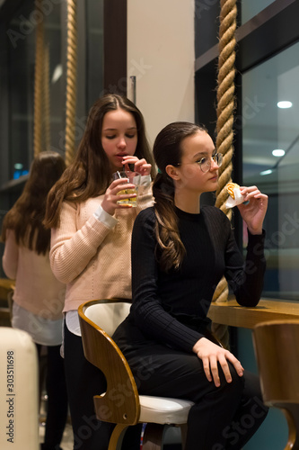 Teen girls eats a biscuit at the bar