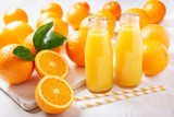 bottles of fresh orange juice with fresh fruits