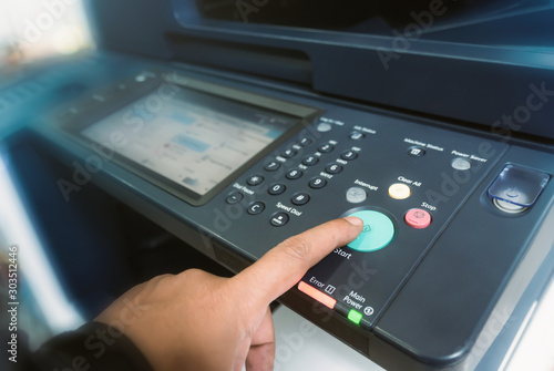 Man touch startup copying paper from Photocopier with access control for scanning in the office business 