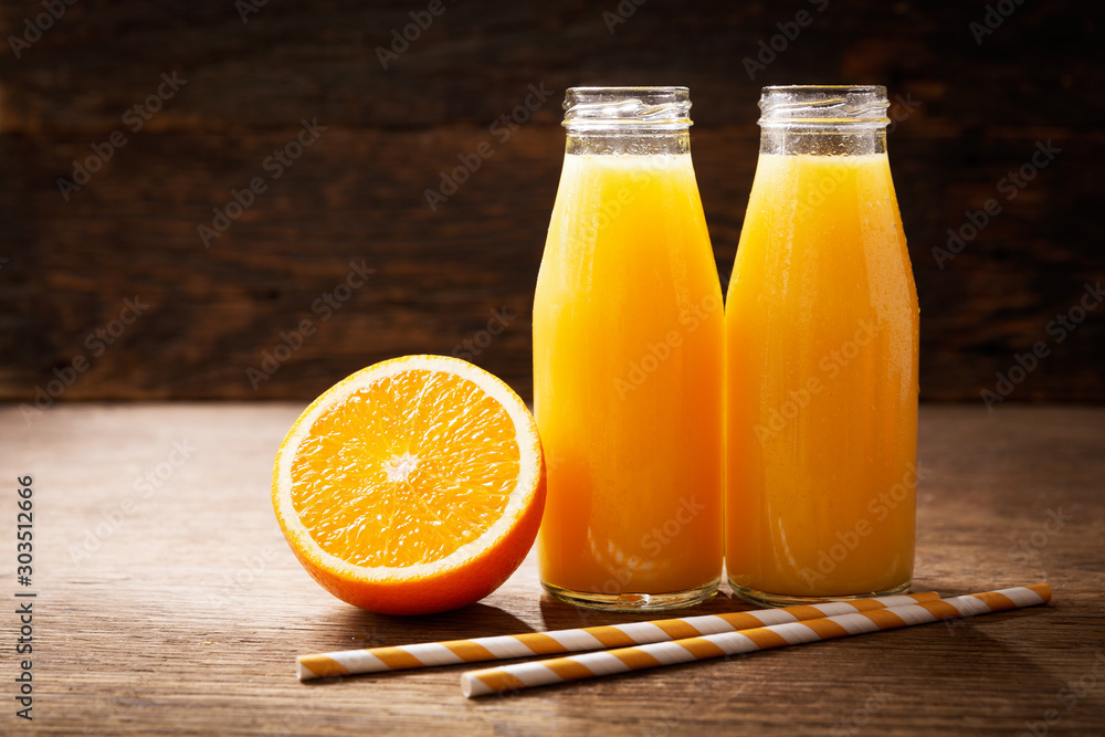 Foto bottles of fresh orange juice on a wooden background