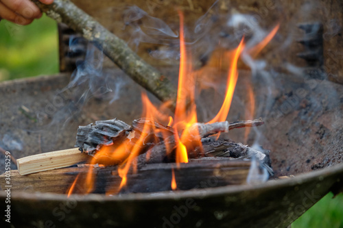 Flames coming out of a heap of cardboard, paper, wood and twigs before in a barbecue used to lighten it up before putting the charcoal in