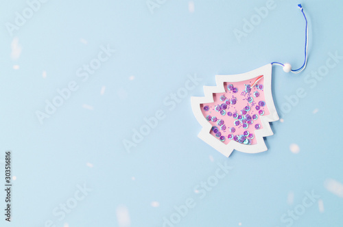 creative Christmas tree, Christmas tree figure with sequins inside on blue background, snow simulation