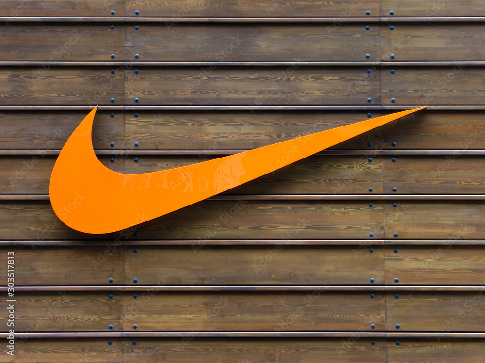 LONDON, UK - CIRCA MAY 2012: Orange Nike logo on a wooden wall at the official Nike store at Westfield Stratford City shopping centre. foto de Stock | Stock