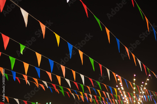 vintage colorful flag banner ribbon on dark sky background in street carnival celebration