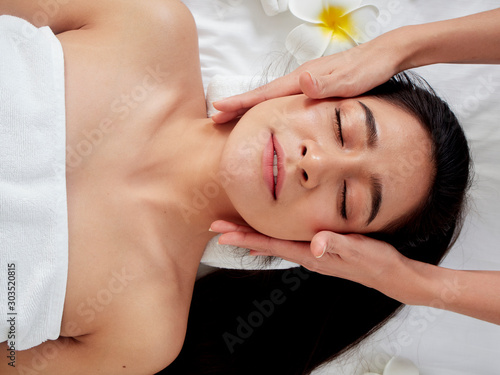 Beautiful woman receiving facial massage in spa.