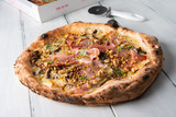 Deliziosa pizza gourmet con spek, gorgonzola, funghi, noci e pistacchio 