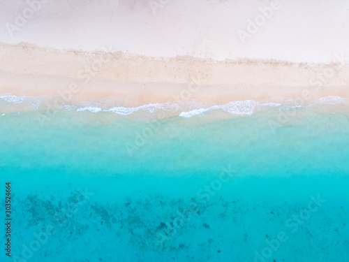 Top view of beach with white sand and turquoise sea water