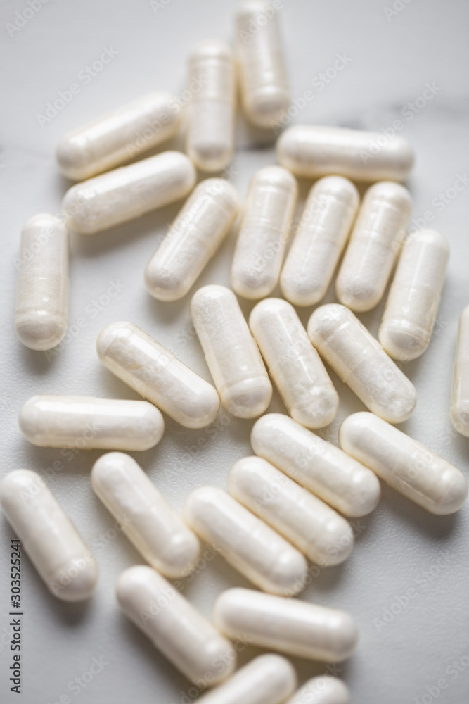 Heap Of Drugs with Glucosamine Sulphate capsules on marble background with copy space Heap Of Drugs with Glucosamine Sulphate capsules on marble background with copy space
