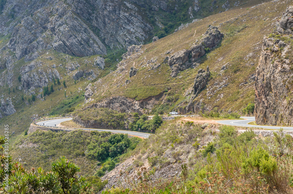 Mountain winding road background. Dramatic rocky landscape with car on a road