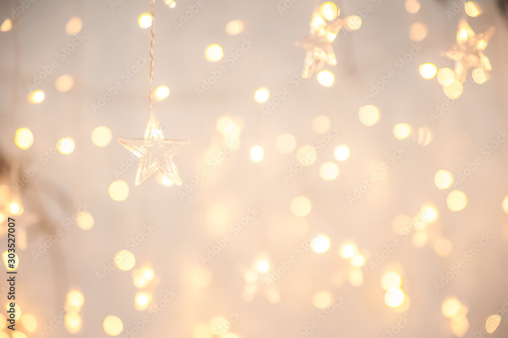Background of New Year's garlands like stars. Christmas atmosphere with garlands in focus and defocus. - obrazy, fototapety, plakaty 