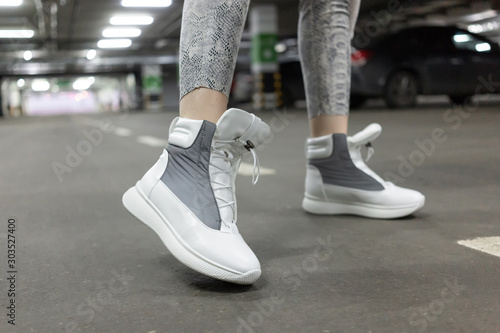 sneakers leather white gray demi season. On foot  a model in an underground parking lot. Close up