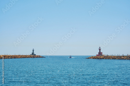 Fototapeta Naklejka Na Ścianę i Meble -  Harbor entrance at the port lighthouse-Tunisia, Sousse, El Kantaoui 06 19 2019