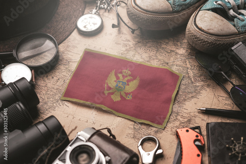 Montenegro Flag Between Traveler's Accessories on Old Vintage Map. Tourist Destination Concept.