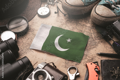 Pakistan Flag Between Traveler's Accessories on Old Vintage Map. Tourist Destination Concept.