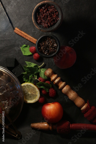 bowl with tobacco for hookah. fruits on a black background. smoking hookah