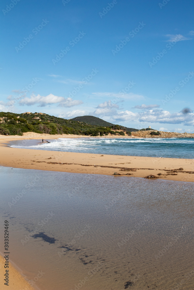Mediterranean sea coast with beach, sun and cloudy sky. Sea and vacation in winter, yellow beach and waves that reach the shoreline. Blue and emerald green water