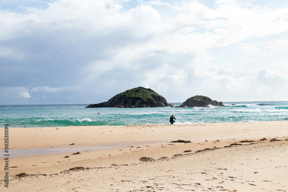 Mediterranean sea coast with beach, sun and cloudy sky. Sea and vacation in winter, yellow beach and waves that reach the shoreline. Blue and emerald green water