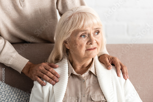 cropped view of retired man standing near sick wife