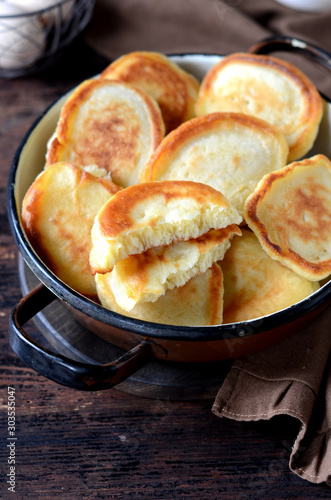 overhead breakfast shot with tasty fried russian pancakes in a bowl on a dark wooden table