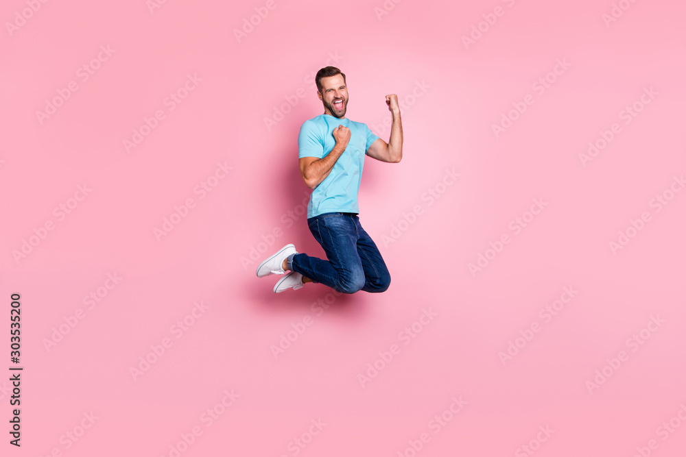 Full length body size profile side photo of cheerful screaming ecstatic man rejoicing in victory his team in jeans denim jumping isolated pastel color background Full length body size profile side photo of cheerful screaming ecstatic man rejoicing in victory his team in jeans denim jumping isolated pastel color background